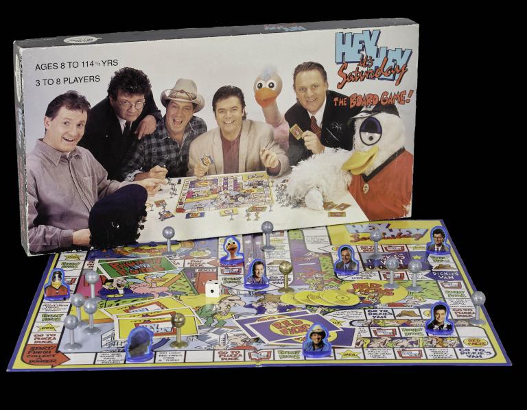 Board game box and pieces for 'Hey Hey It's Saturday' with colorful graphics and characters