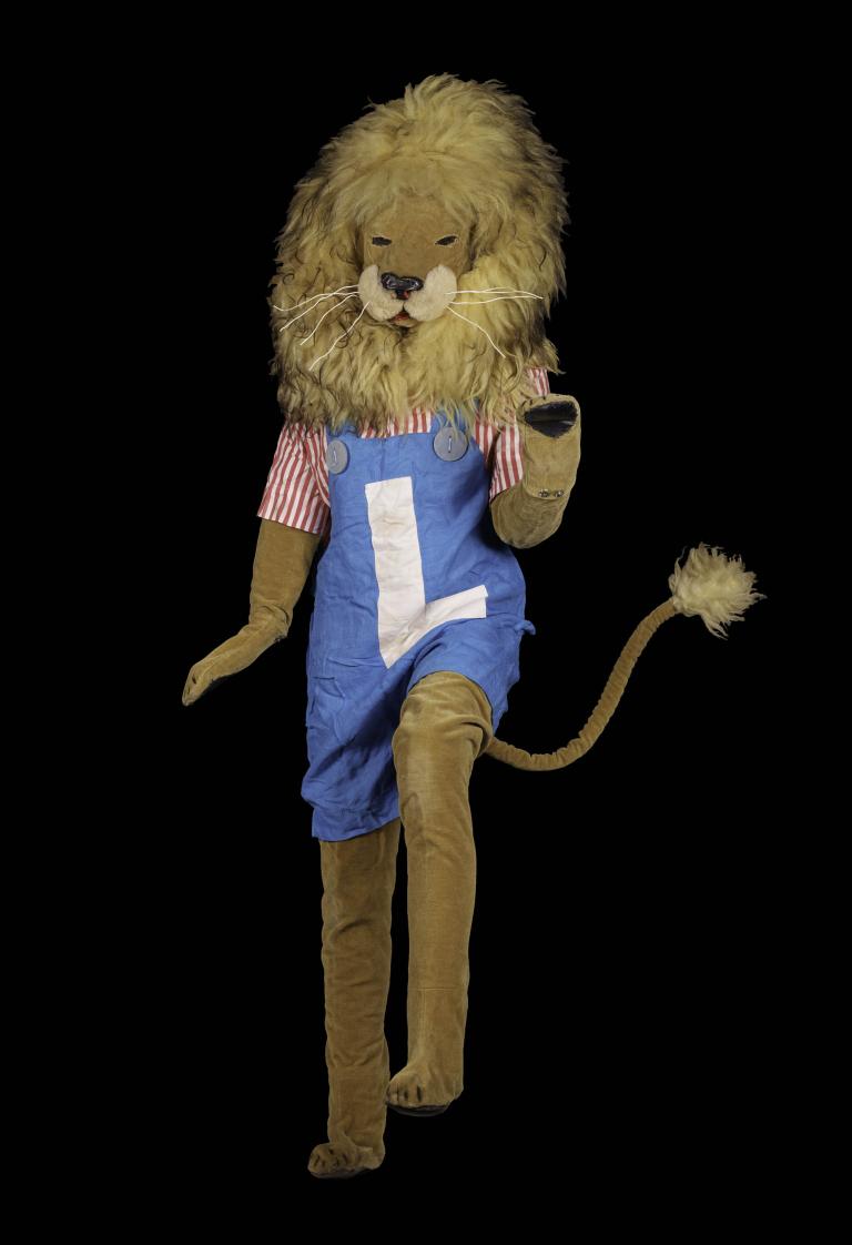 Person dancing in Lenny the Lion costume from The Bobo Show (1965), in blue overalls and stripes