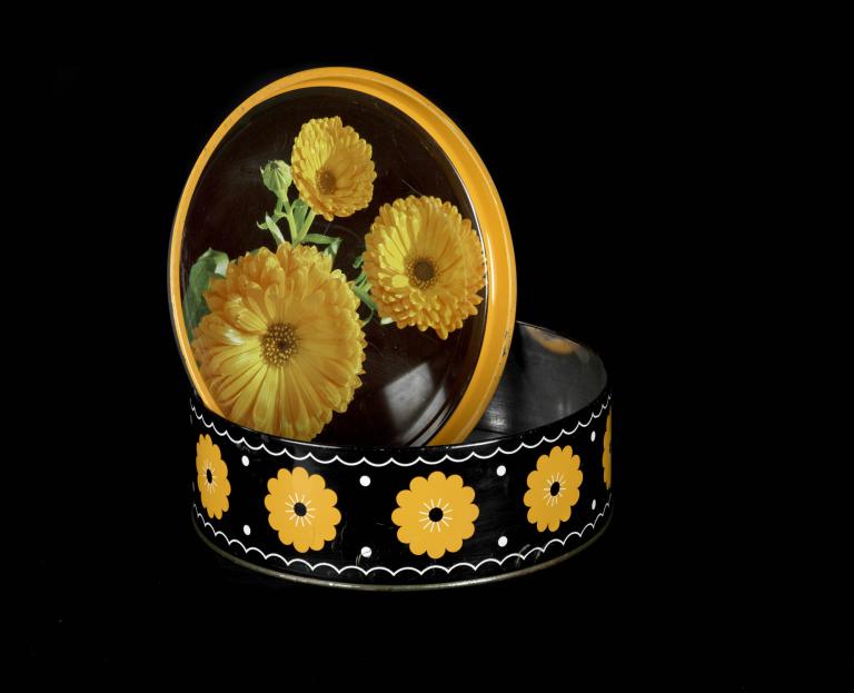 Yellow flower tin container with lid featuring calendula design on black background