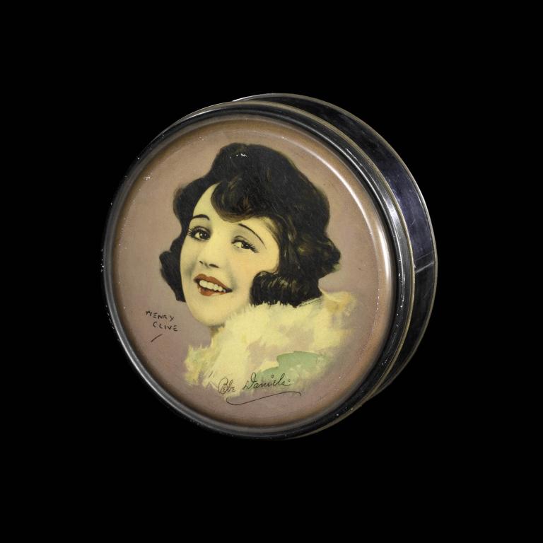Vintage tin lid featuring Bebe Daniels, a famous 1920s actress, with artwork by Henry Clive