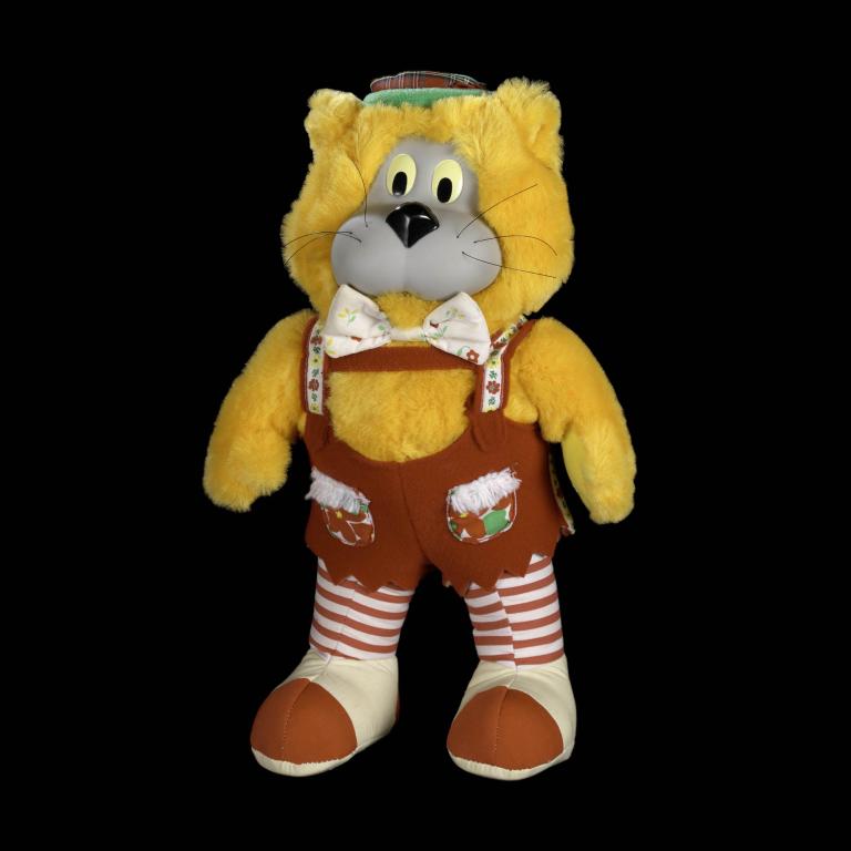 Stuffed yellow cat toy with brown overalls and a hat, 1986 design