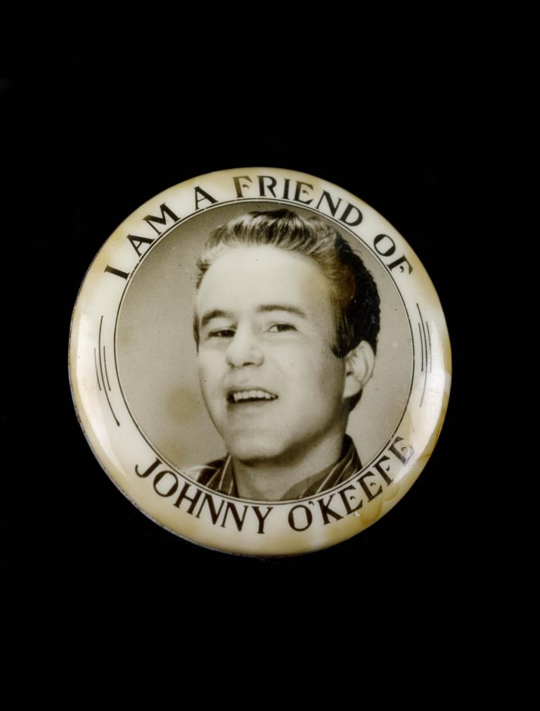 Promotional badge with text 'I am a friend of Johnny O'Keefe' featuring a black and white portrait