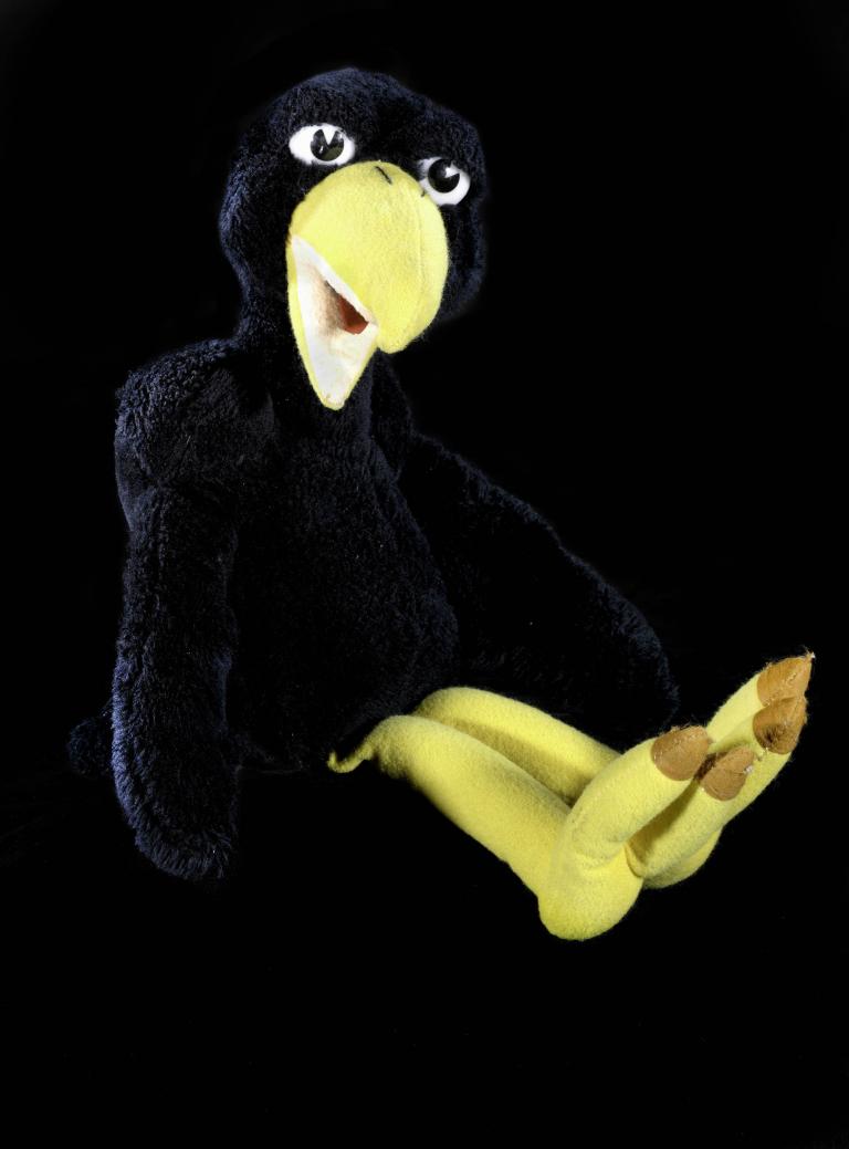 Black and yellow puppet crow against a black background, from an Australian TV show