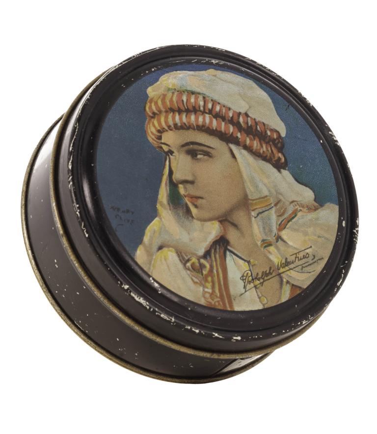 Vintage tin depicting Rudolph Valentino in traditional attire, early 1920s collectible