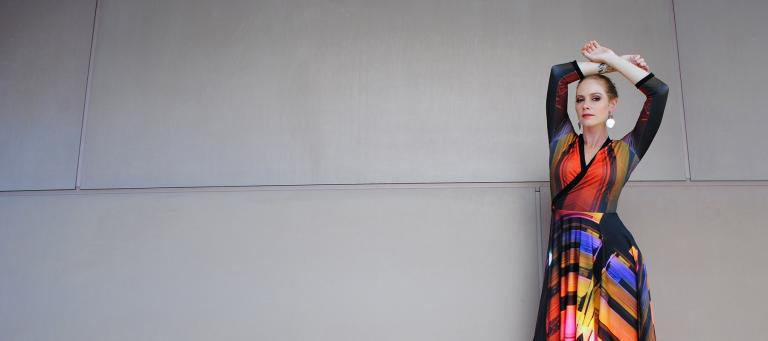 Model posing against a wall, wearing Yumi Morrissey's NFSA building dress