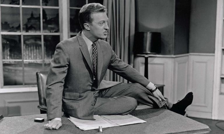 Graham Kennedy sitting on top of his desk in the IMT studio, circa 1957