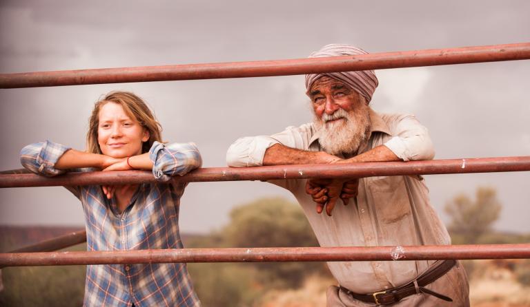 Mia Wasikowska and John Flaus leaning on a fence in a scene from the movie Tracks