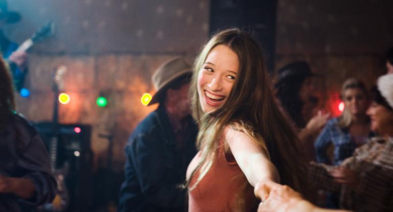 Sophie Lowe laughing and looking at the camera in a scene from the film Beautiful Kate