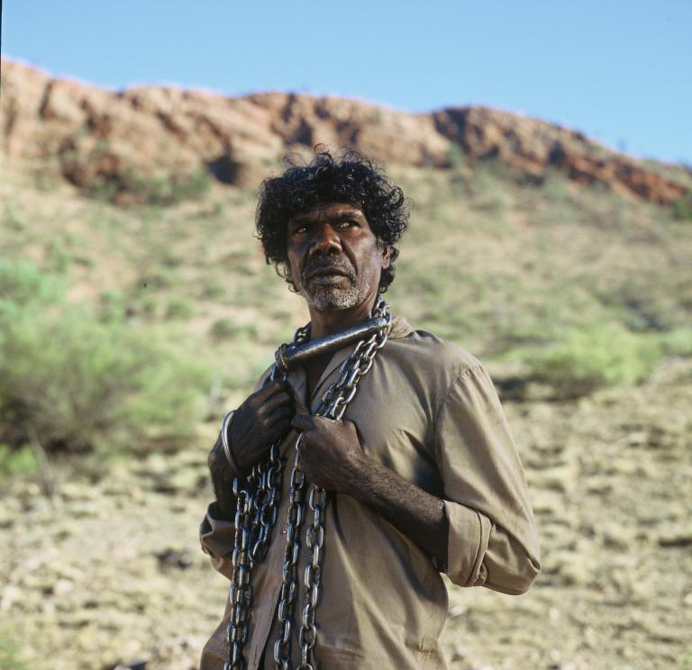 David Gulpilil as The Tracker, with a chain around his neck, in a scene from the 2002 film The Tracker
