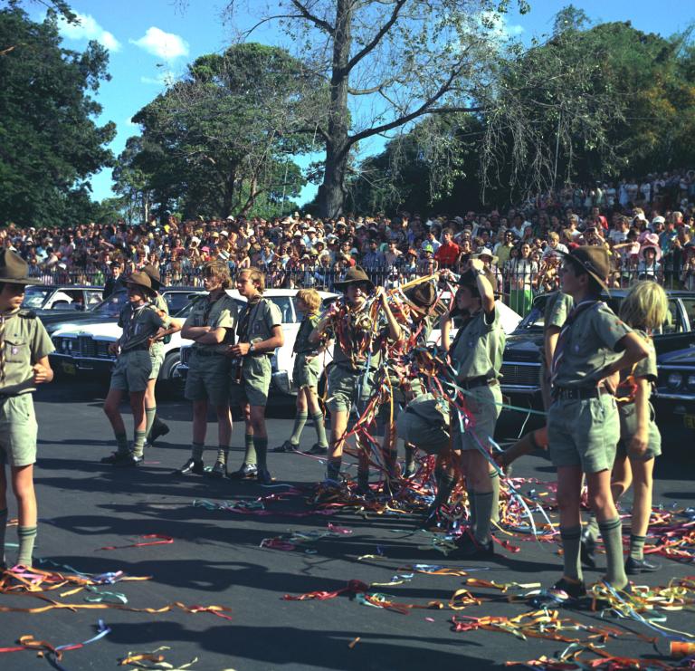 Boy scouts play with coloured streamers with crowds of people behind them at the official opening of the Sydney Opera House.
