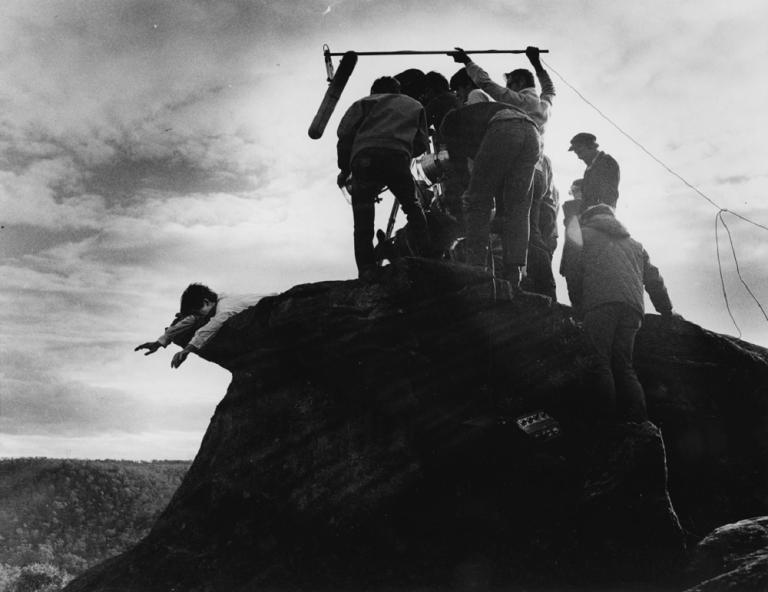 David Downer being filmed on the Skippy set hanging over a cliff.