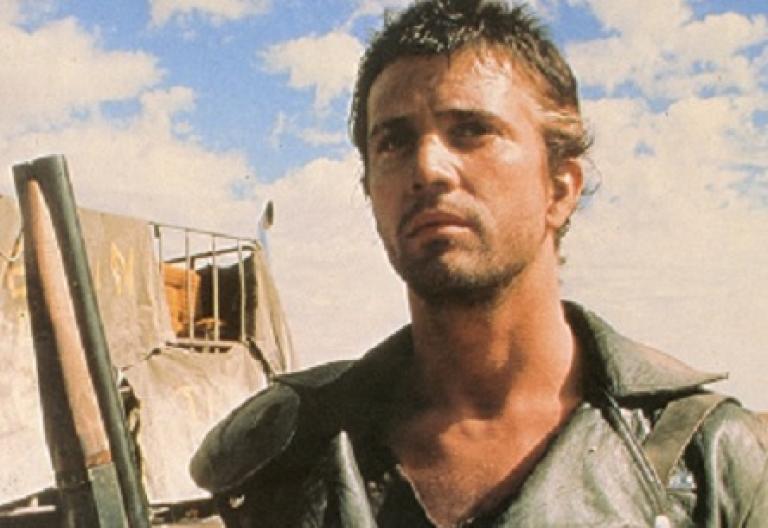 Mad Max 2 lobby card featuring Max (Mel Gibson) holding a sawn-off shotgun