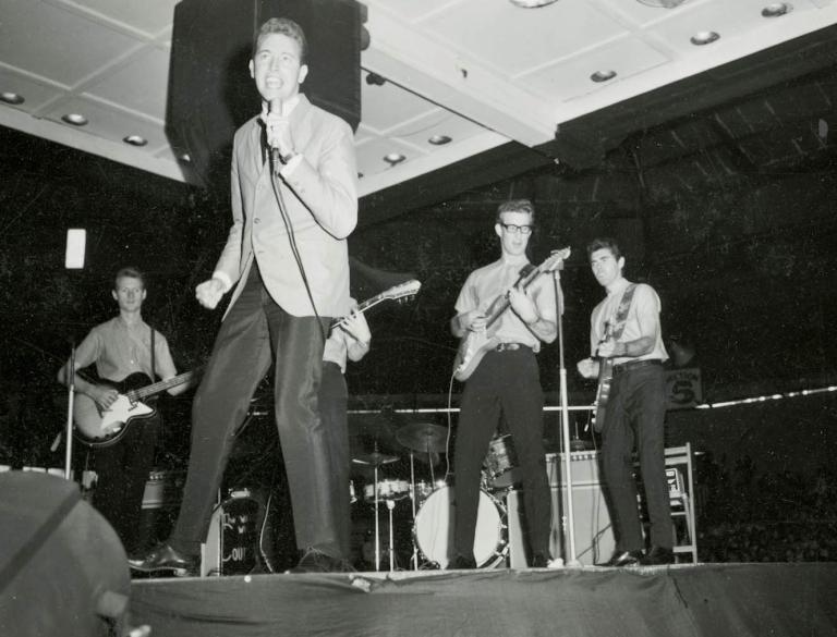 Black and white photo of Jimmy Hannan singing with a backing band at Sydney Stadium