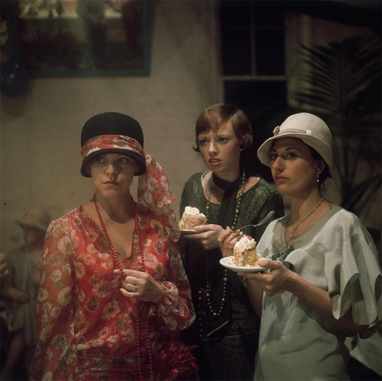 Film still of Lynette Curran as Maudie with her friends, played by Lorna Lesley and Vivienne Garrett wearing period costume and eating cake in the film, Caddie.