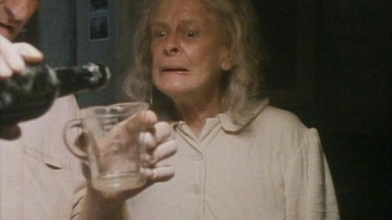 Grandma (Gwen Plumb) watching her son-in-law (Martyn Sanderson but largely unseen) pour some brandy