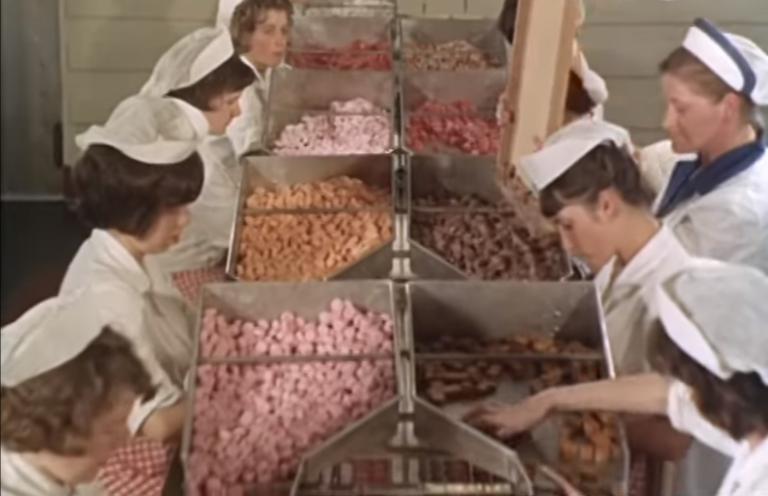 Women working in a chocolate factory, inspecting and sorting out the product