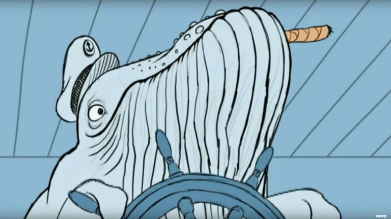 An animated image of a whale wearing a sailor's cap. The whale has a cigar in its mouth and is using its flippers to steer a ship.