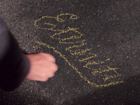 Image of a hand writing 'Eternity' in chalk on the sidewalk