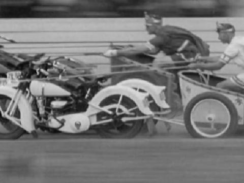 Two men dressed as ancient Romans race motorcycles like chariots