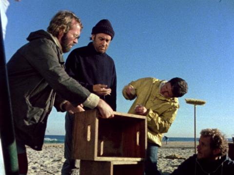 Stand-by props person and production designer crew on a film set with actor Peter Cummins on the beach set of Storm Boy