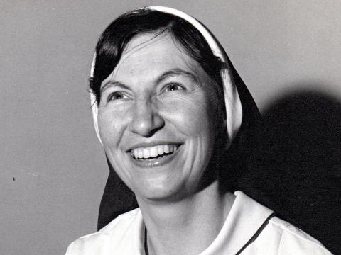 Head and shoulders shot of a nun smiling.
