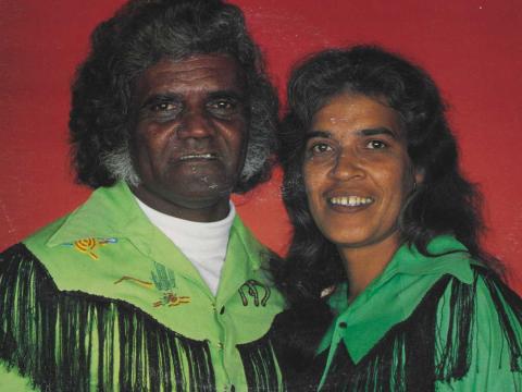 Head and shoulders shot of First Nations Country musicians Harry and Wilga Williams wearing matching green Country music style shirts with black fringing.