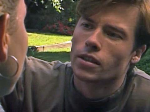 Guy Pearce in Neighbours leaning in to talk to someone