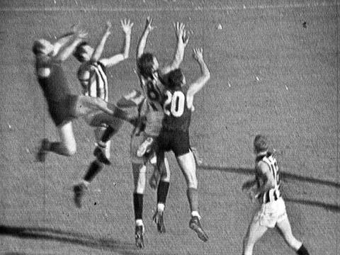 Australian Rules Football players jumping for the ball in the 1964 grand final match.