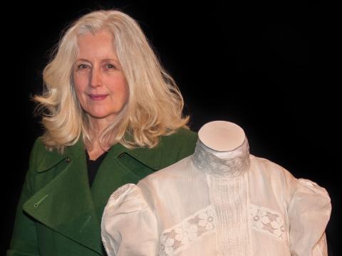 Anne Louise Lambert stands next to a mannequin wearing the white muslin dress she wore in Picnic at Hanging Rock 40 years earlier
