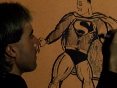 Presenter drawing Superman on wall of comic book store, sepia-toned.