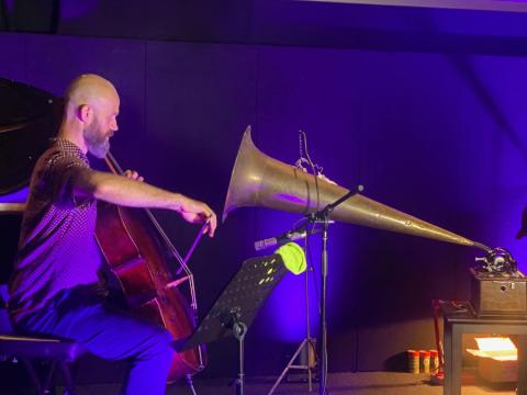 Christopher Pidcock plays the cello into a large gramophone horn attached to an Edison phonograph.
