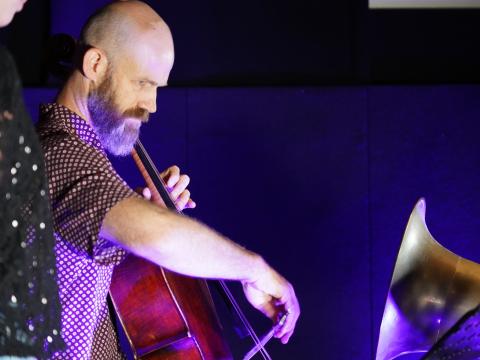 Christopher Pidcock plays the cello into a large gramophone horn, to record a wax cylinder.