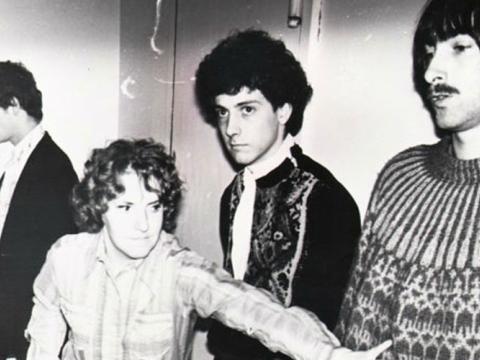 Four people stand in a line. 