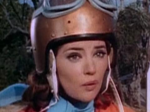 Frame capture of of actress Jeanie Drynan wearing a helmet and goggles.