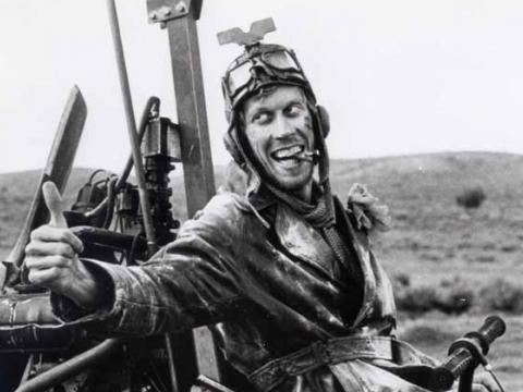 Crazy looking man in a gyrocopter gives a thumbs up gesture
