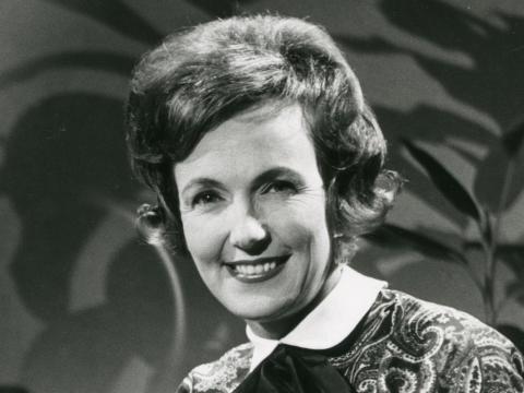 Head and shoulders shot of a young woman smiling at camera, c1960.