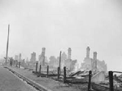 Row of houses completely burnt with only the chimneys remaining.