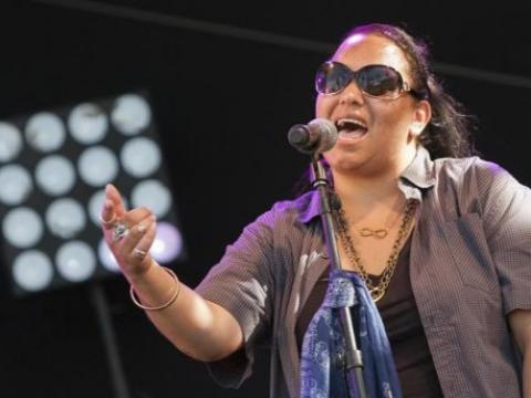 A young Indigenous singer performs live.