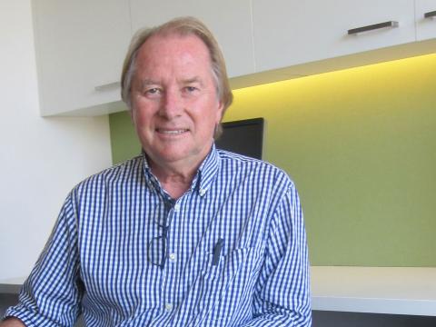 Glenn Wheatley, pictured from the waist up, smiling at camera in 2014.