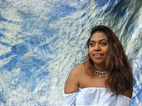 Portrait of Emily Wurramara wearing an off-the-shoulder dress.
