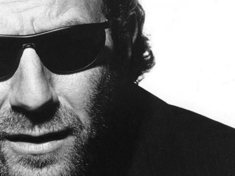 Austen Tayshus wearing dark glasses in black and white close-up.
