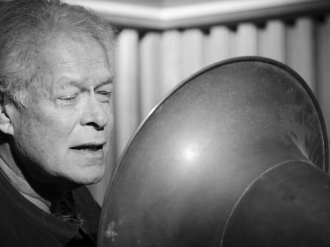Black and white image of Keith Potger recording a song on wax cylinder