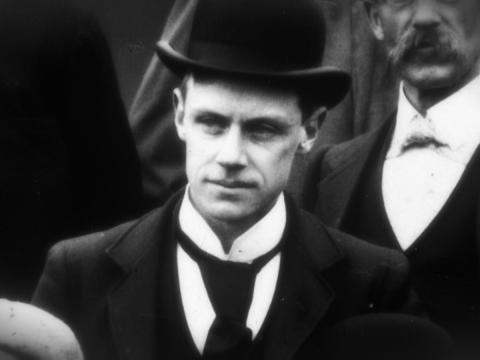 Black and white portrait of Thomas Rome wearing hat and tie