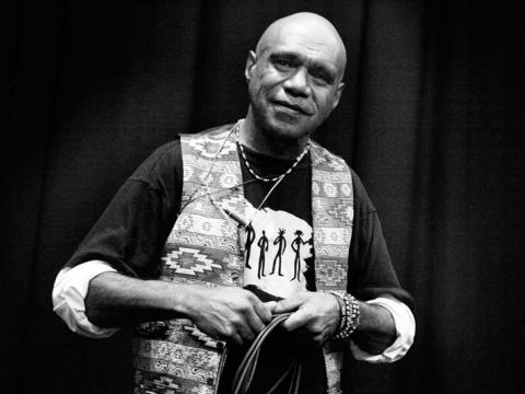 Archie Roach posing for the camera in this black and white portrait.