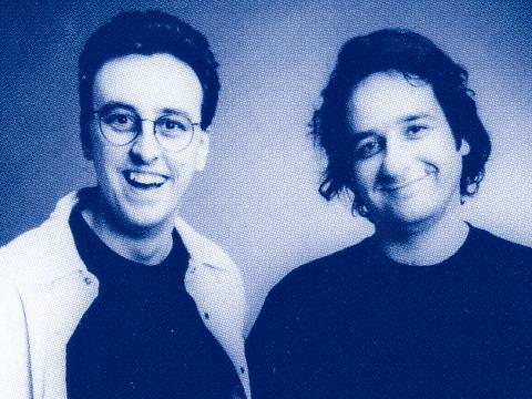 Tony Martin and Mick Molloy pictured from the chest up, smiling directly at camera
