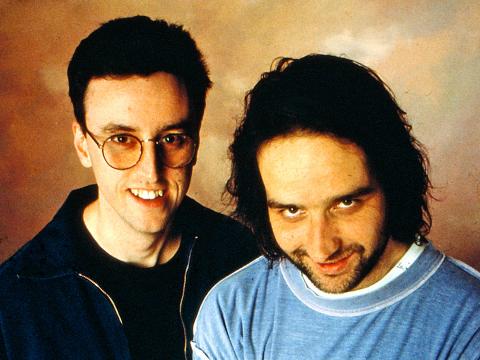Head and shoulders photo of comedians Tony Martin and Mick Molloy look upwards toward camera and smiling