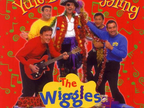 An album cover with a photograph of The Wiggles and Captain Feathersword. The text reads 'Yule Be Wiggling: The Wiggles'.