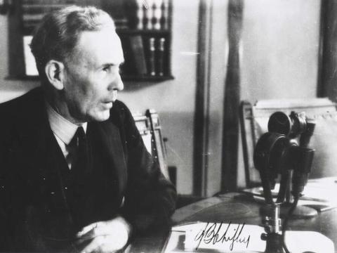 Prime Minister Ben Chifley speaking into a microphone.