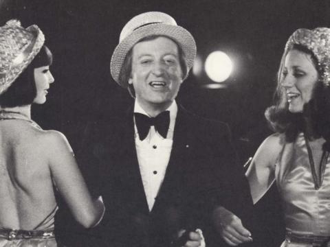 Graham Kennedy standing between two girls in the movie version of The Box