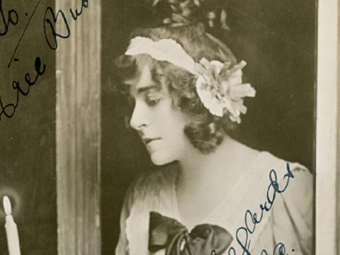 Frances Alda holding a lit candle.